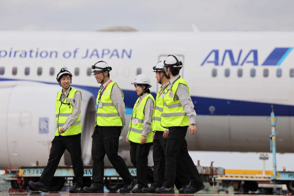 飛行機と作業服を着用した整備士4名