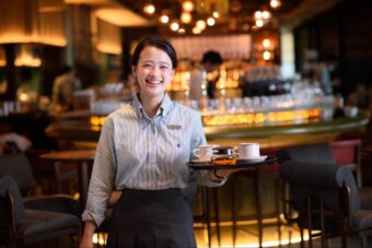 グレーの制服を着用したレストランスタッフ