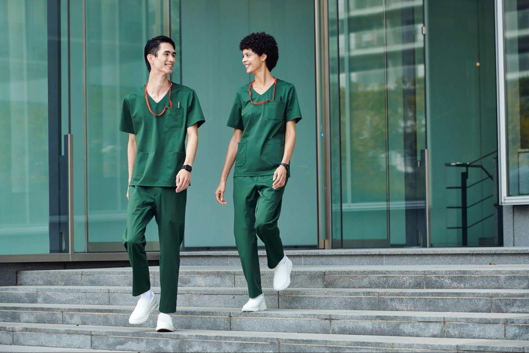 グリーンの制服を身につけたクリニックのスタッフ2人