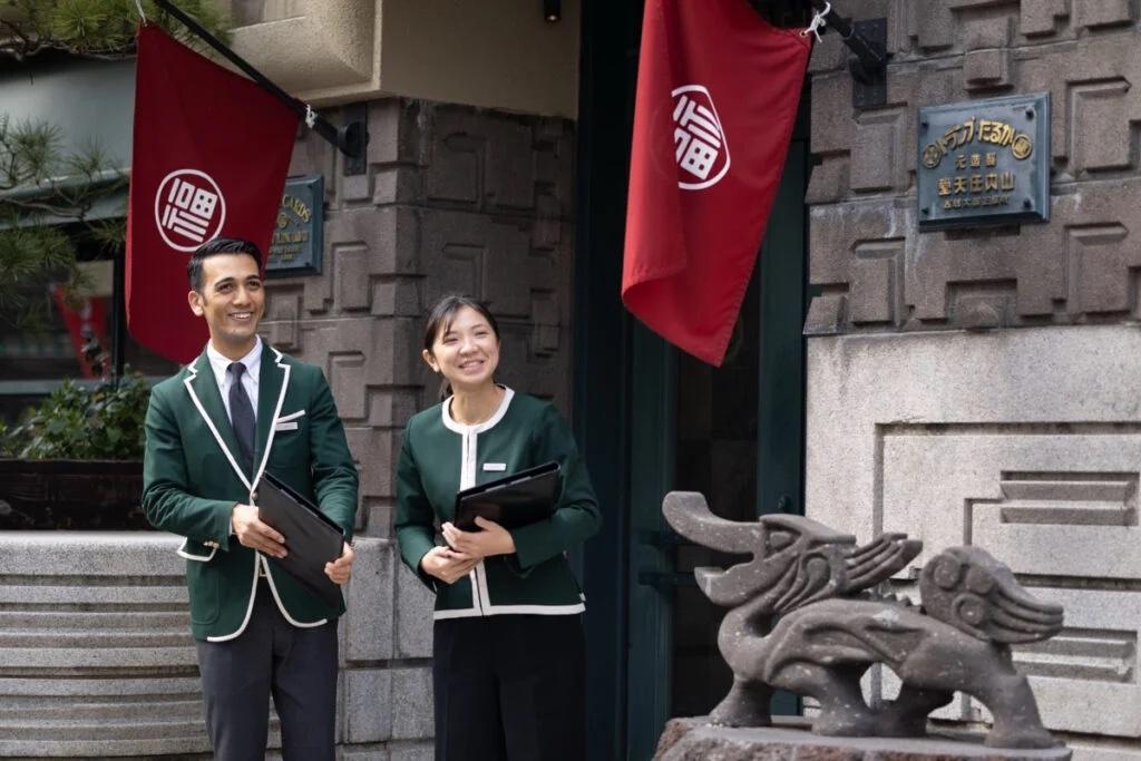 深緑の制服を着用した男性スタッフと女性スタッフ