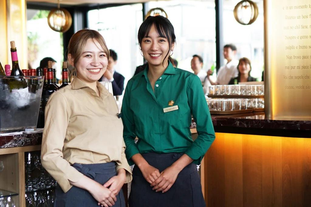 ベージュと緑のブラウスを着用した女性スタッフ