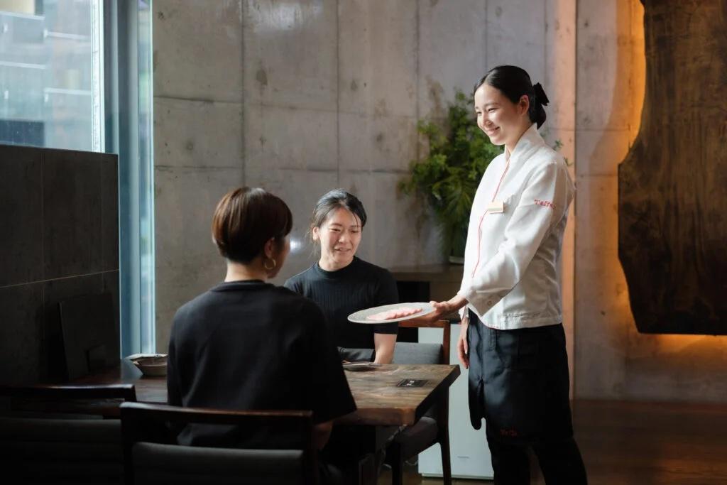 白と黒の制服を着たスタッフが配膳している様子