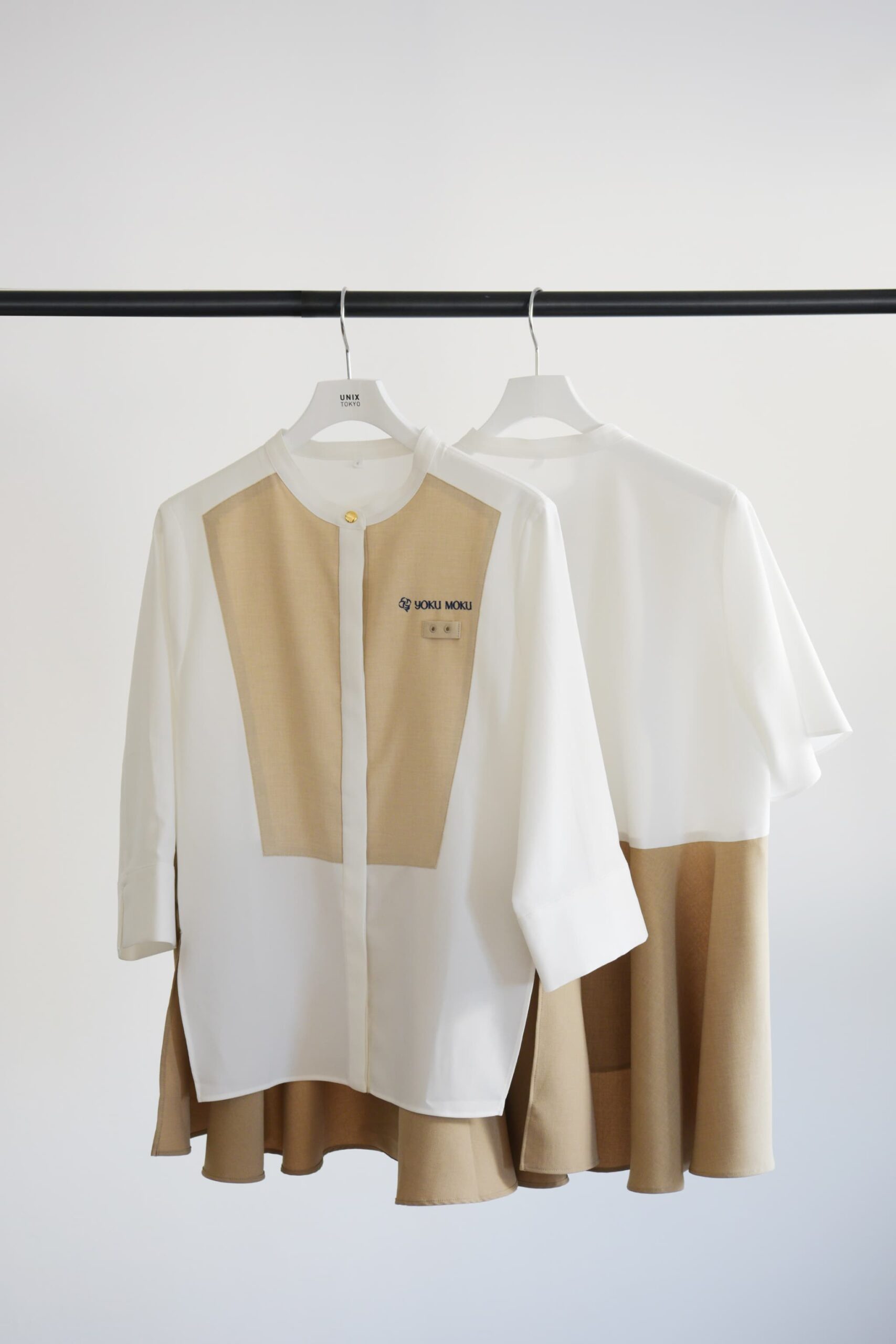 ヨックモックの制服のブラウス。白とベージュを基調とした洗練されたデザイン。