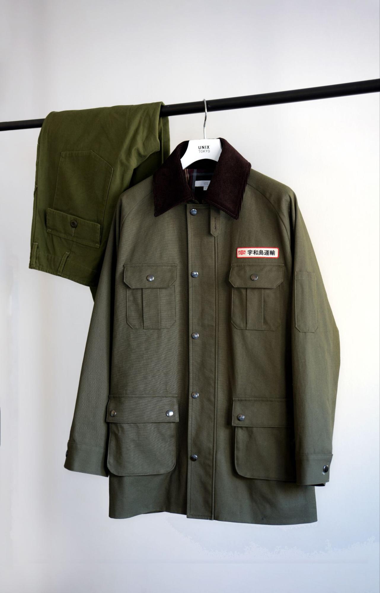 ハンガーにかけられたカーキ色のジャケットとワークパンツ