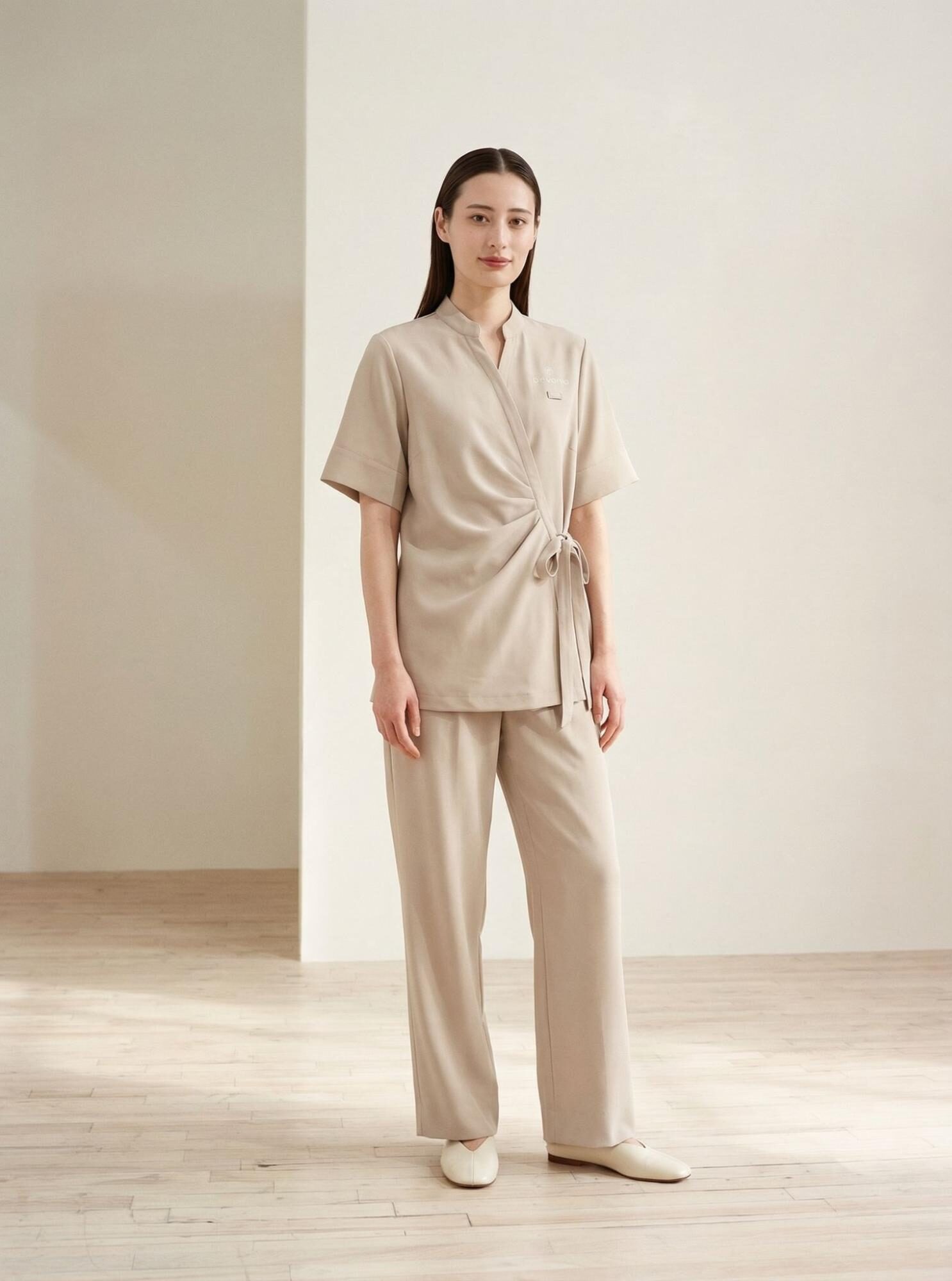 ライトベージュのユニフォームを着用した女性