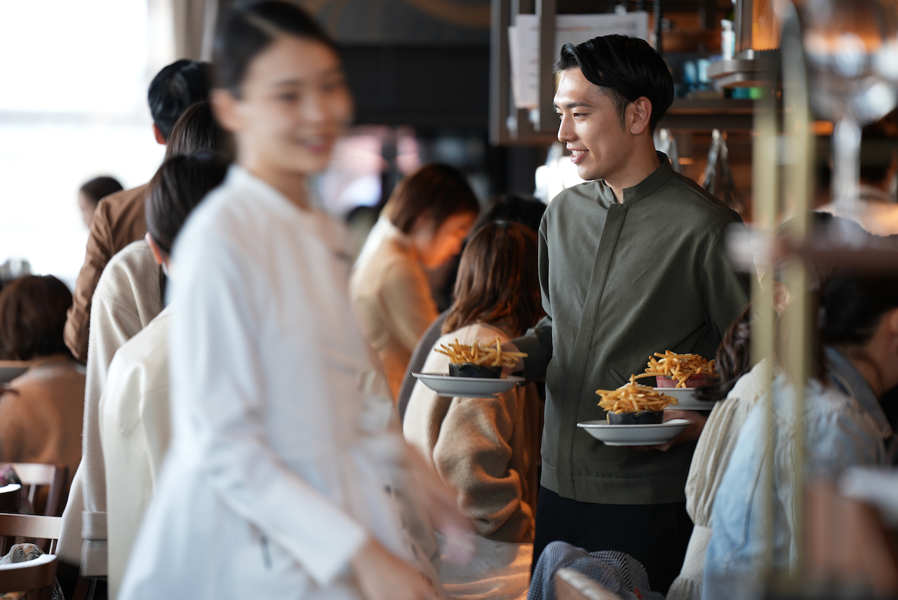 グレーの制服を着用したレストランスタッフの様子