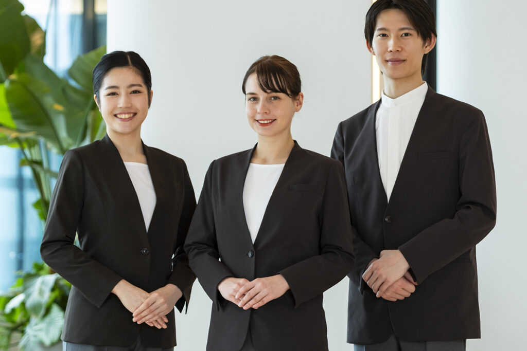黒のジャケットと白のインナーの制服を着用したホテルスタッフ3名